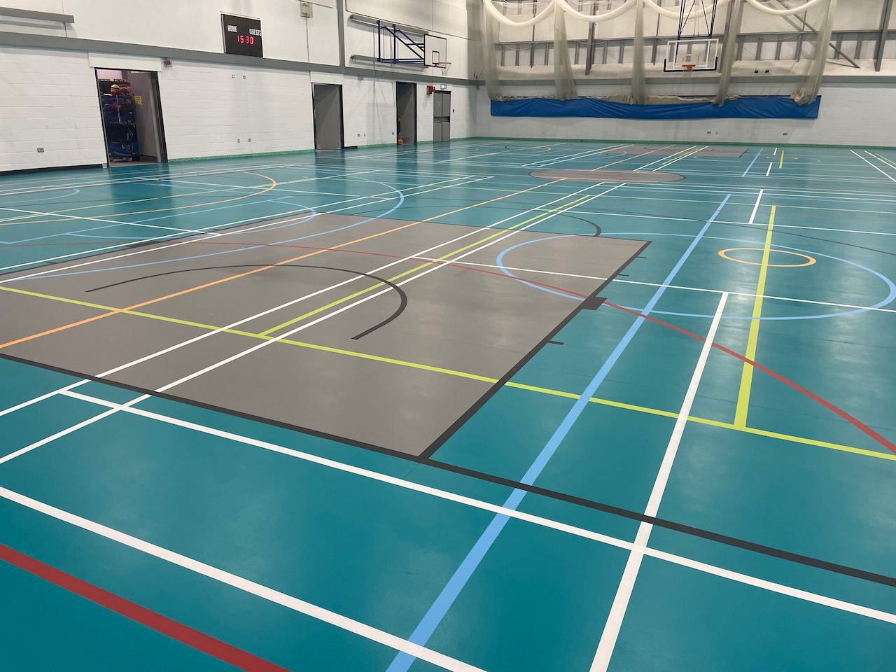 Multi-sport court markings on a teal sports hall floor