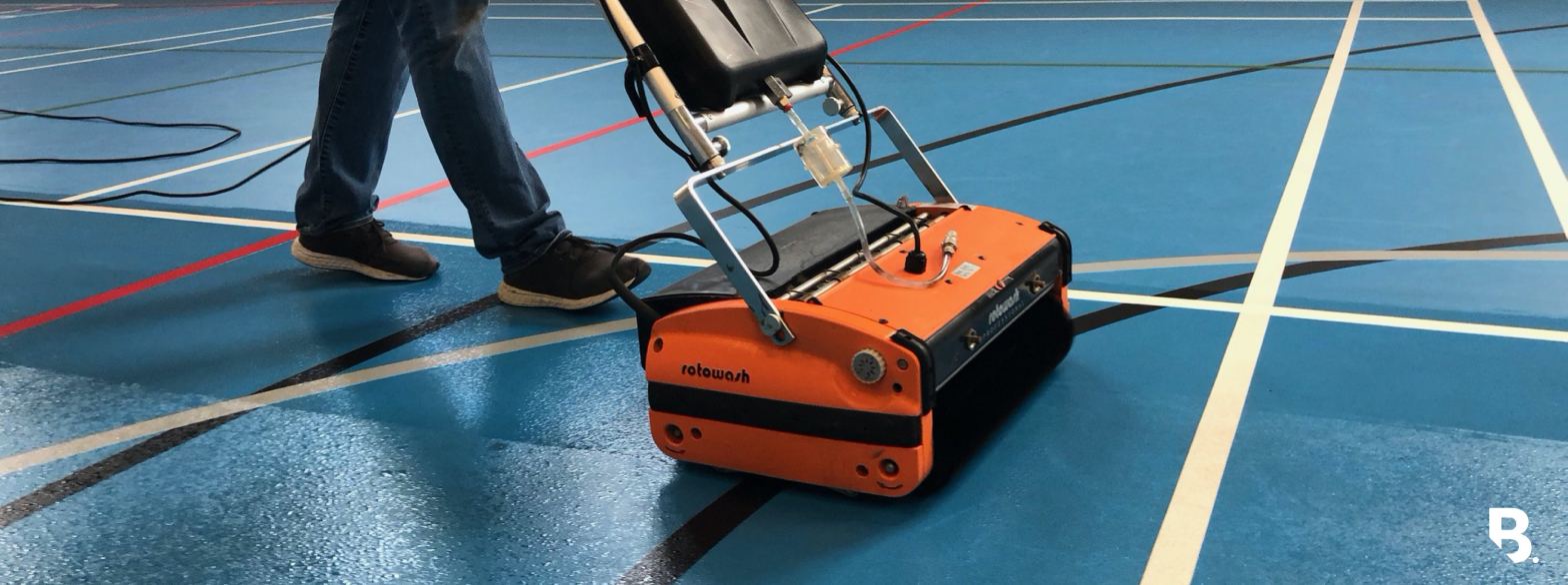 Rotowash machine cleaning a blue sports floor